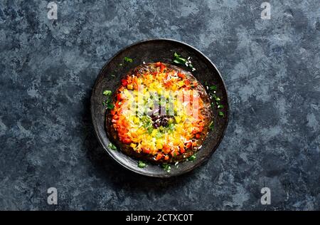 Rainbow veggie bell peppers pizza crust on plate over blue stone background with free text space. Vegetarian vegan or healthy food concept. Top view, Stock Photo
