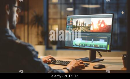 Over th Shoulder Shot: Young Professional Videographer Works on Desktop Computer, Doing Footage Montage, Using Video Editing Software. Modern Video Stock Photo
