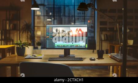 Shot of a Desktop Computer Standing on a Desk with Professional Video Montage Editing Software. In the Background Warm Evening Lighting and Open Space Stock Photo