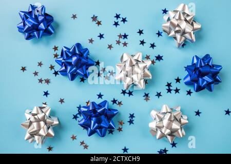 shiny Gift bows of silver and blue metallic colors with confetti isolated on blue background.ribbon knots for present wrapping.Set variation colorful Stock Photo