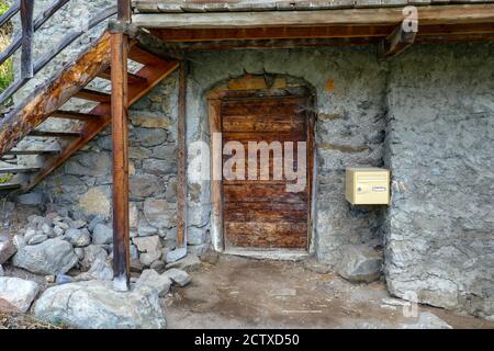 Door in old buildings with stairs and post box,  in the village Puy-Saint-Vincent, ski resort, in summer, Vanoise National Park, Ecrins, France Stock Photo