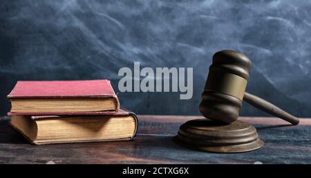 Law gavel, old books and reading glasses on a wooden table, lawyer or judge office desk. 3d illustration Stock Photo