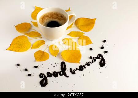 White coffee mug concept: fall yellow with good morning written with coffee ground beans over a white background Stock Photo