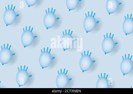 A medical pattern in blue pastel colors made of inflated medical gloves. Stock Photo