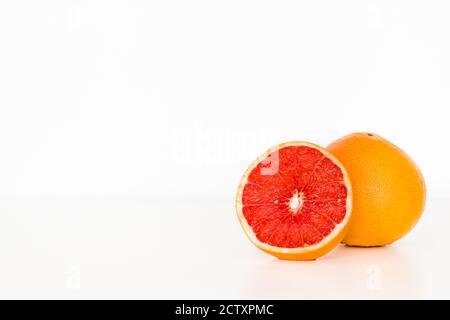 Freshly sliced grapefruit isolated on white table/background. Fruit vitamins. Copy space. Stock Photo