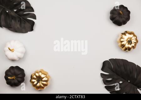 Trendy Halloween Frame with Golden Shiny Decorative Pumpkins. Flat lay, top view trendy holiday concept. Stock Photo
