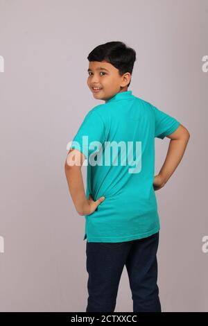 smart young happy indian boy with hands on waist turning back and smiling. Stock Photo