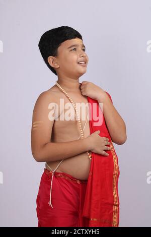 cute Indian boy in ethnic wear sovla and uparna - dhoti and stole. holding his stole. Stock Photo