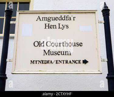 A sign in both the Welsh and English languages, at the entrance to the Old Courthouse Museum, in the town of Beaumaris on the Isle of Angelsey in Wale Stock Photo