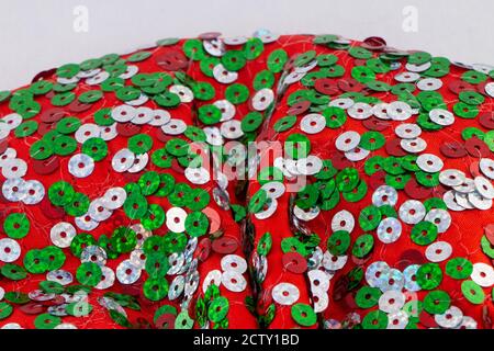 Christmas colors, red, green and silver shiny sequins on large red bow Stock Photo