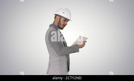 Engineer walking and working on digital tablet on gradient backg Stock Photo