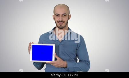 Smiling casual man presenting a tablet with a blank screen on gr Stock Photo