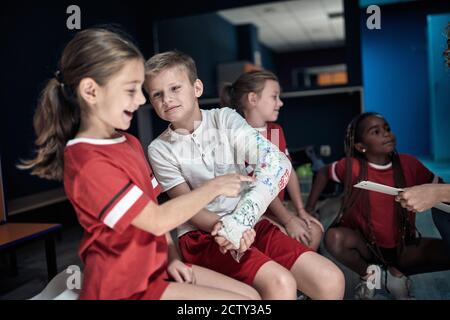 Injured a little soccer player and his team mates in a locker room Stock Photo