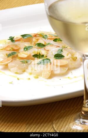 scallops seasoned with herbs, olive oil and almond flakes Stock Photo