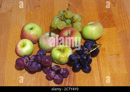 Grapes of three colors with apples close-up on wooden Stock Photo