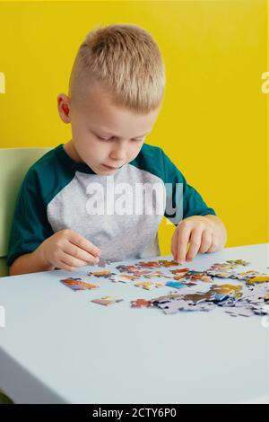 the kid making puzzles .The concept of board educational games.  Stock Photo