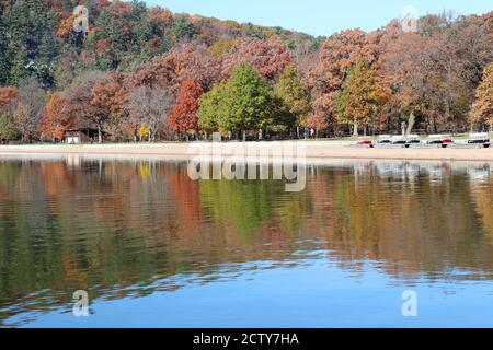 Wisconsin nature background. Scenic autumn landscape with colorful trees on the hill reflected in lake water. Devil's Lake State Park, Baraboo, Wi USA.