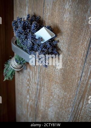 Bunch of lavenders (lavendula) with message written on piece of paper hanging on door handle. Stock Photo