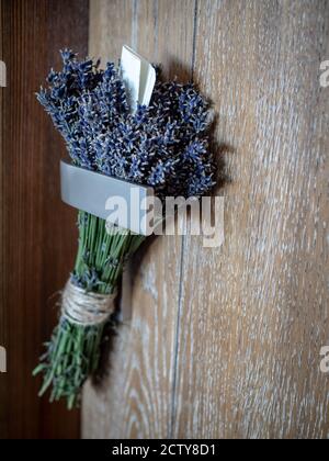 Bunch of lavenders (lavendula) with message written on piece of paper hanging on door handle. Stock Photo