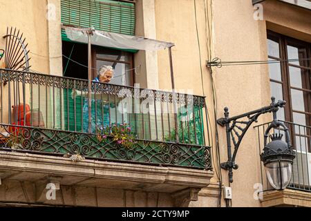 Barcelona, Spain 05/01/2010: An elderly caucasian lady with gray hair is standing in the tiny balcony of her apartment. The flat is in a very old buil Stock Photo