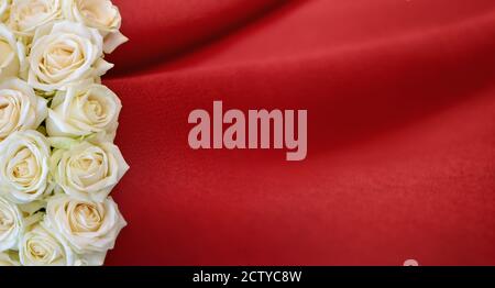 Bouquet of white roses on a red fabric Stock Photo