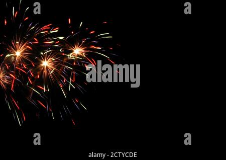 Festive colorful fireworks on the black sky as a background with copy space. Stock Photo