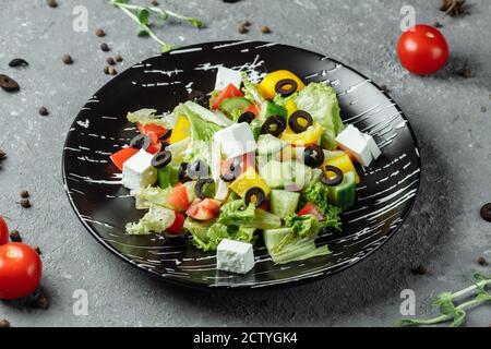 Greek Salad with Cucumeber, Kalamata Olives, Feta Cheese, Juicy Cherry Tomatoes and Fresh Basil. Concept for a tasty and healthy vegetarian meal Stock Photo