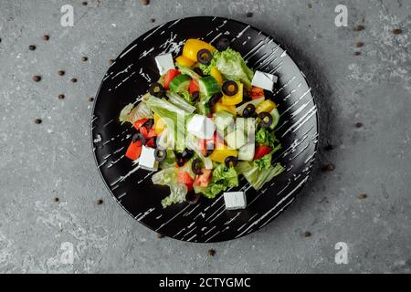 Greek Salad with Cucumeber, Kalamata Olives, Feta Cheese, Juicy Cherry Tomatoes and Fresh Basil. Concept for a tasty and healthy vegetarian meal Stock Photo