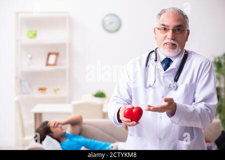 Two doctors visiting sick man at home Stock Photo