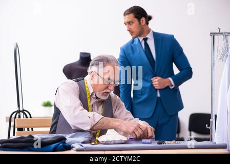 Young businessman visiting old tailor Stock Photo