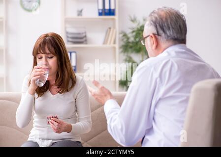 Young woman visiting old doctor psychologist Stock Photo