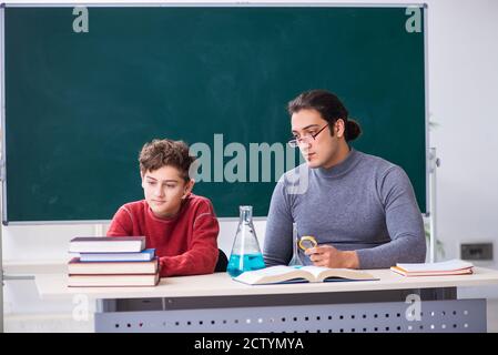 Young teacher and schoolboy in the classroom Stock Photo