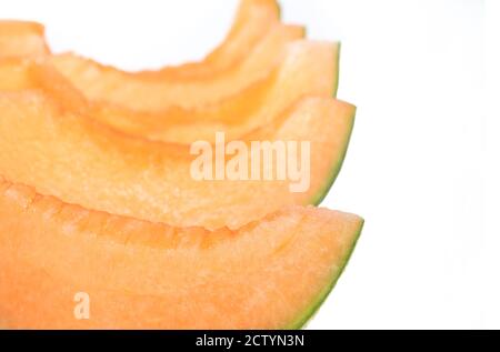 Cantaloupe melon cut in snack slices, no seeds. Also known as rockmelon, sweet melon or spanspek (Cucumis melo). Orange sweet flesh, netted rind. Stock Photo