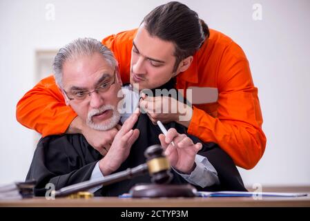 Old judge meeting with young captive in courthouse Stock Photo