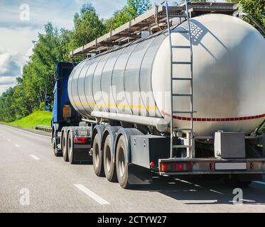 big gas-tank truck goes on highway against the sky Stock Photo