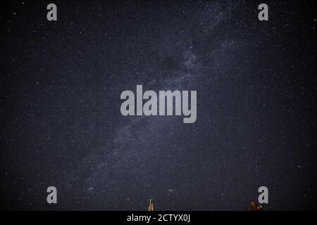 in the night sky you can see the milky way and the traces of satellites Stock Photo