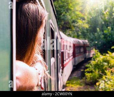 Woman looking out the window of the old train. Bulgarian mountains, Alpine railway in the Balkans Stock Photo