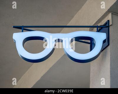 Sign in the shape of an eyeglasses frame on a wall. Stock Photo