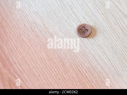 brown sewing button on a wooden background Stock Photo