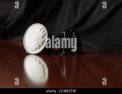 detail of italian espresso coffee capsules with reflection in the wood Stock Photo