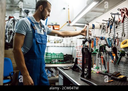 Bicycle assembly in workshop, man holds fork Stock Photo