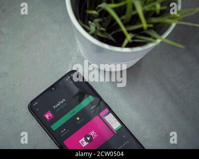 Lod, Israel - July 8, 2020: Modern minimalist office workspace with black mobile smartphone with Pink Park app play store page on marble background. T Stock Photo