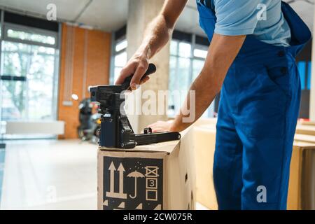 Bicycle shop, man holds box with new bike Stock Photo