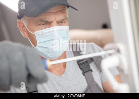 Worker man installs plastic windows and doors with double-glazed white Stock Photo