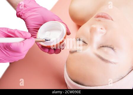 Close-up young woman applying cream for skin care with brush. Spa beauty treatment concept Stock Photo
