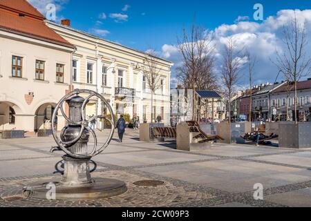 Kielce, Poland, March 2019 Vintage water pump with large wheel on main city square in Kielce with town hall in the background Stock Photo