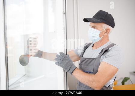 Worker man installs plastic windows and doors with double-glazed white Stock Photo