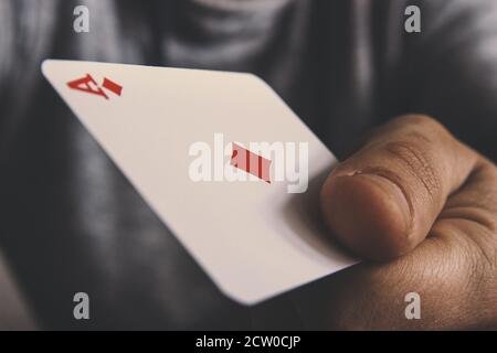 A man holds in his hand a tambourine ace, a concept of card and gambling, and a casino. Playing cards. Stock Photo