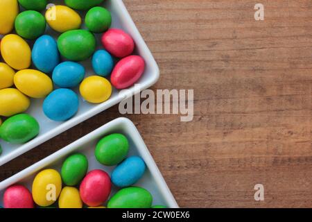 Colorful jelly beans candies in a bowl on wooden background. Sweet holiday treats for kids Stock Photo