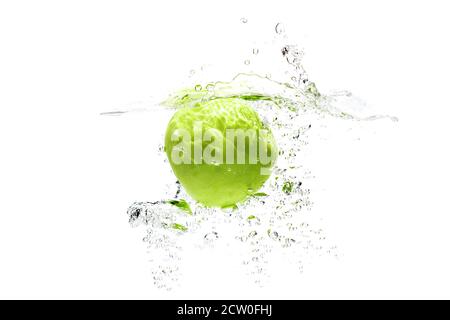 one green apple falling into water on a white background with splashes, drops and bubbles. Stock Photo